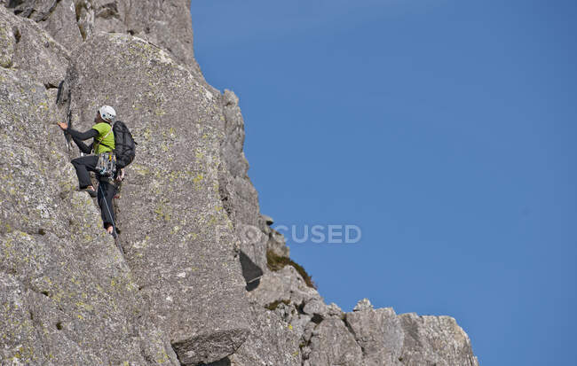 Homme escalade la paroi rocheuse sur Tryfan dans le nord du Pays de Galles — Photo de stock