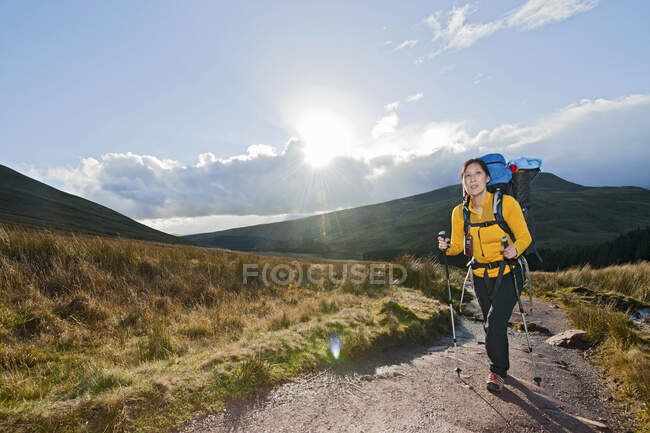 Женщина-туристка, идущая в сторону Pen Y Fan в Уэльсе — стоковое фото