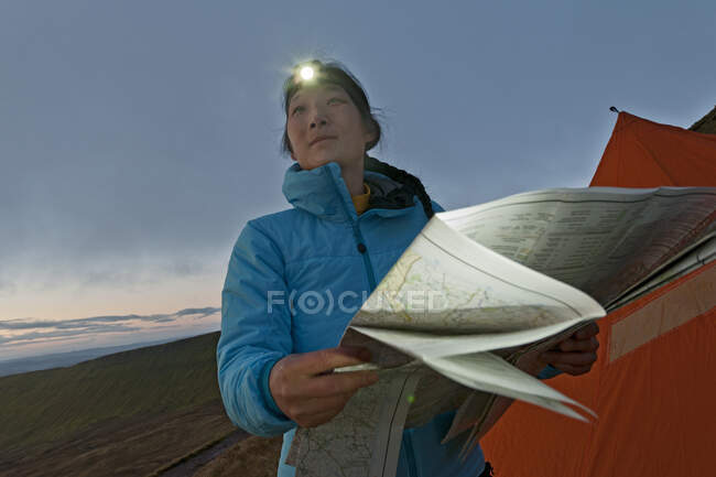 Caminhante feminino leitura mapa da caminhada em Pen Y Fan, País de Gales, ao nascer do sol — Fotografia de Stock