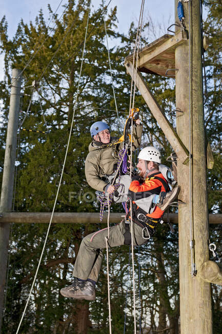 Casal praticando cenário de resgate no exercício de treinamento de corda alta — Fotografia de Stock