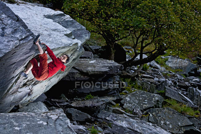 Frau beim Bouldern auf Felsen im Schieferbruch in Nordwales — Stockfoto