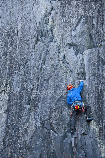 Man climbing up steep rock face at Slate quarry in North Wales — Stock Photo