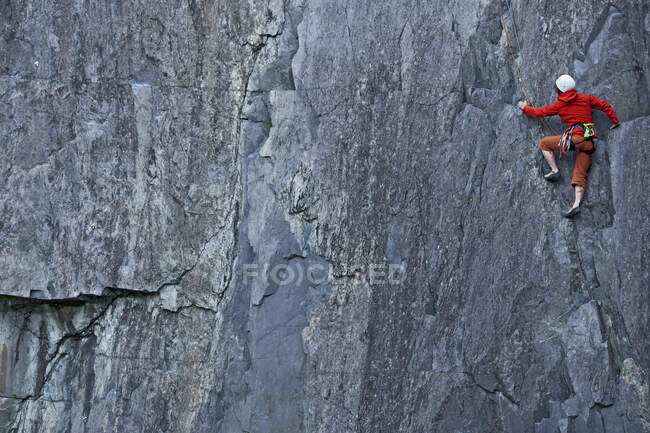 Mulher escalando a face íngreme da rocha na pedreira de ardósia no norte do País de Gales — Fotografia de Stock