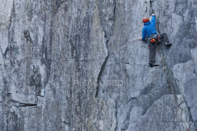 Man climbing up steep rock face at Slate quarry in North Wales — Stock Photo