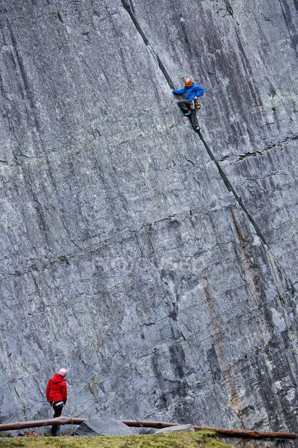 Человек карабкается по крутой скале на карьере Слейт в Северном Уэльсе — стоковое фото