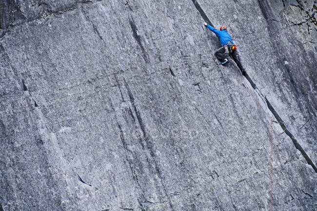 Hombre escalando empinada cara de roca en la cantera de pizarra en el norte de Gales - foto de stock