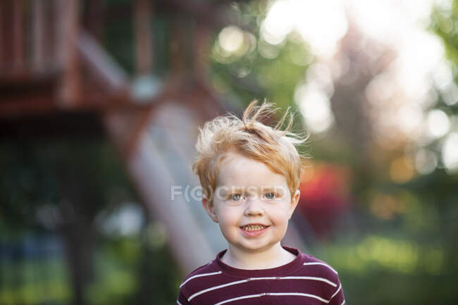 Primo piano del bambino di 3-4 anni che sorride nel cortile durante l'autunno — Foto stock