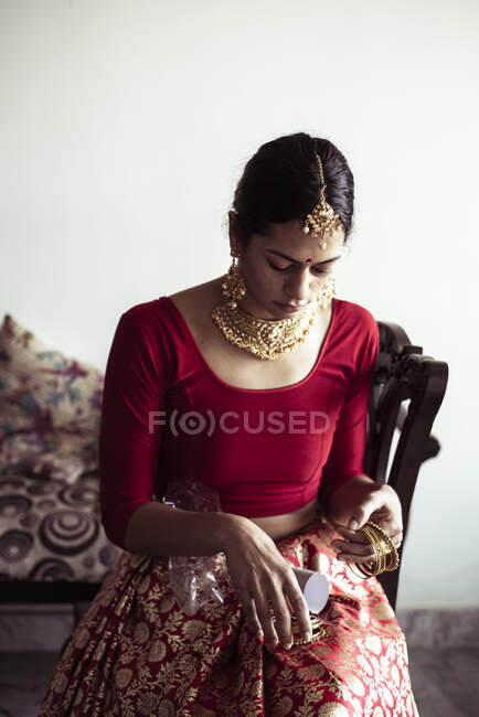 Novia india se prepara para la boda india tradicional con sari rojo - foto de stock