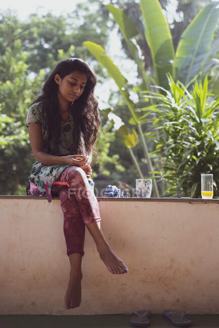 Giovane bella donna indiana con piante tropicali per il caffè del mattino — Foto stock
