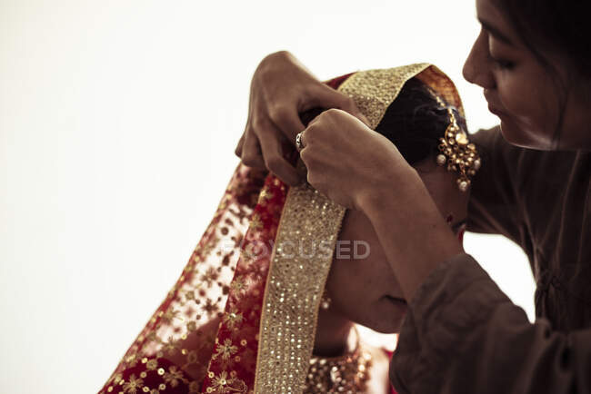 Amigo ajudar noiva indiana preparar véu e sari para casamento tradicional — Fotografia de Stock