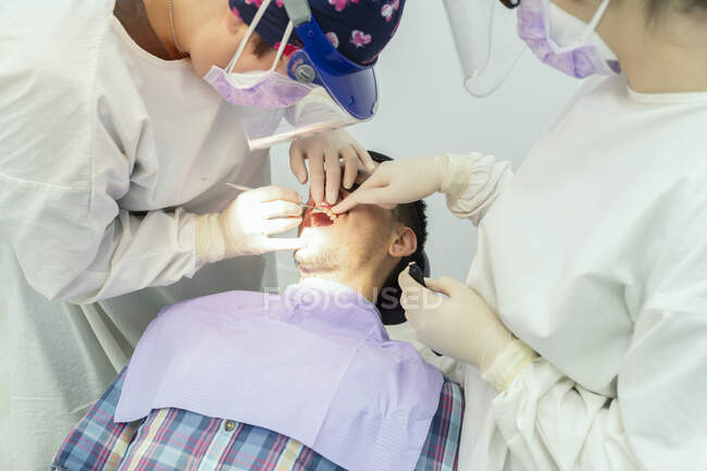Команда стоматологів, що працюють на пацієнта — стокове фото