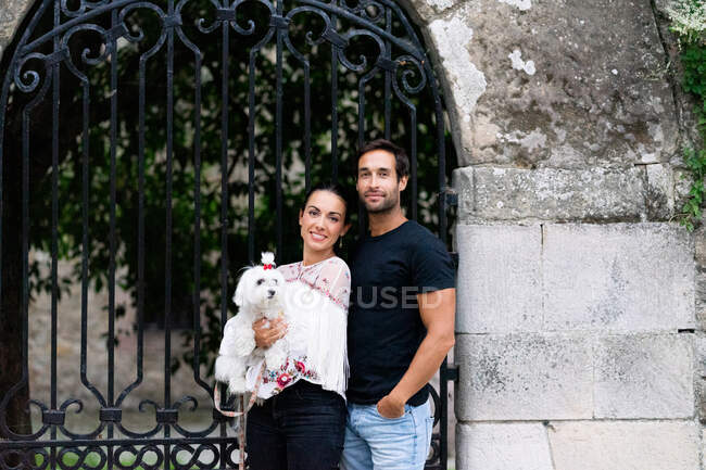 Portrait de jeune couple posant avec leur chien debout à l'extérieur dans la rue. — Photo de stock
