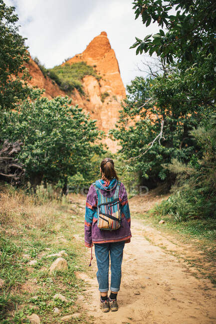 Unerkennbare Frau wandert in der Natur, um einen Aussichtspunkt mit Blick auf eine Felsformation zu erreichen — Stockfoto