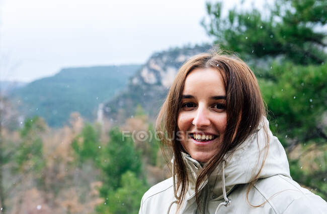 Woman on the mountain enjoying the falling snow. — Stock Photo