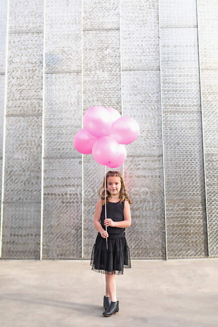 Красива молода жінка гуляє на вулиці з великими рожевими кульками — стокове фото