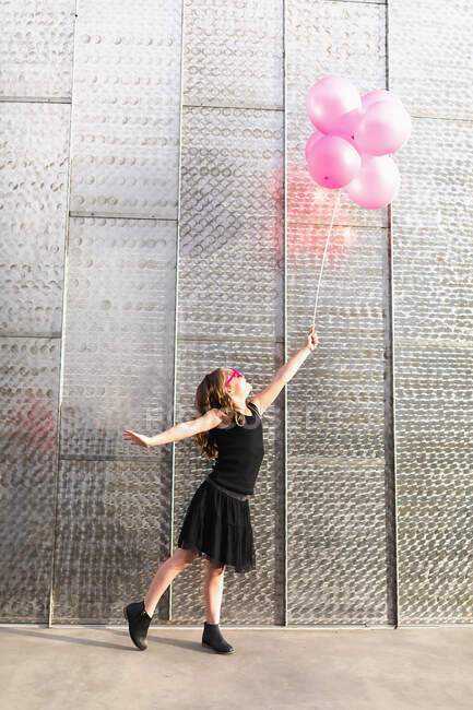 Schöne junge Frau in einem weißen Kleid mit Luftballons — Stockfoto