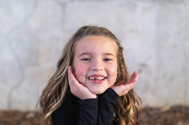 Retrato de una linda niña con una sonrisa en la cara - foto de stock