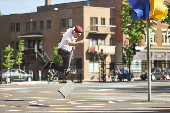 Man doing 360 flip while skateboarding in park, Montreal, Quebec, Canadá - foto de stock