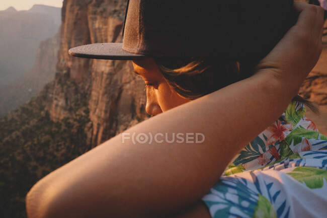 Boy in Hawaiian Shirt Looks Down the Desert Canyon at Sunset. — Stock Photo