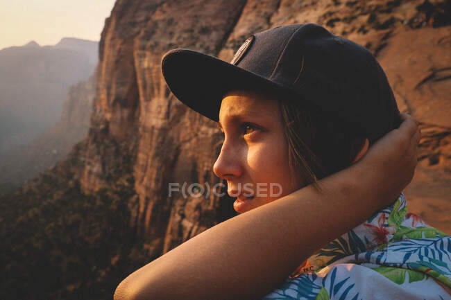 Junge im Hawaiihemd überblickt bei Sonnenuntergang die Wüstenschlucht. — Stockfoto