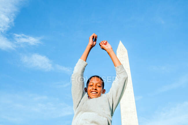 Молодой афро-американец прыгает перед монументом Вашингтона — стоковое фото