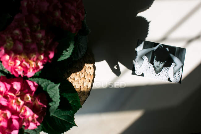 Fotografia stampata sul tavolo con fiori rosa — Foto stock