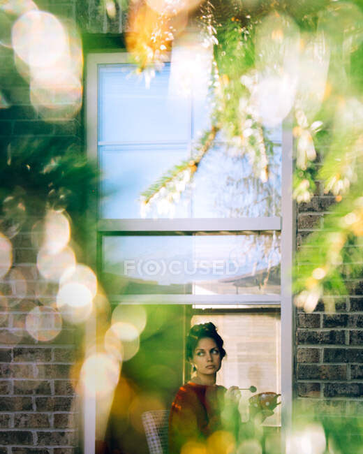 Женщина сидит у окна с чашкой — стоковое фото