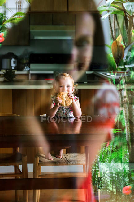 Mujer fotografiando chica a través de la ventana - foto de stock