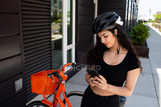 Jovem mulher com bicicleta na cidade — Fotografia de Stock