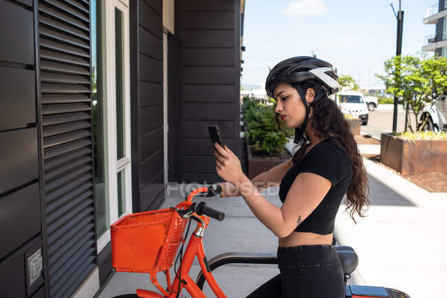 Молода жінка з мобільним телефоном і смартфоном на вулиці — стокове фото