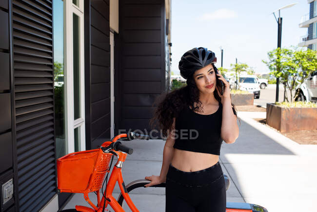 Молодая женщина с велосипедом в городе — стоковое фото