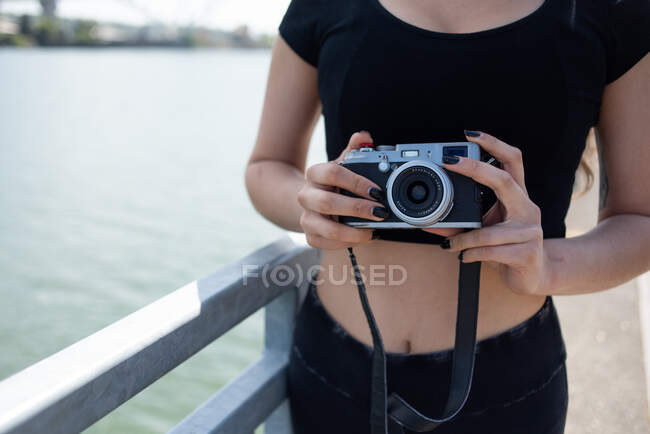 Giovane donna con macchina fotografica sulla spiaggia — Foto stock