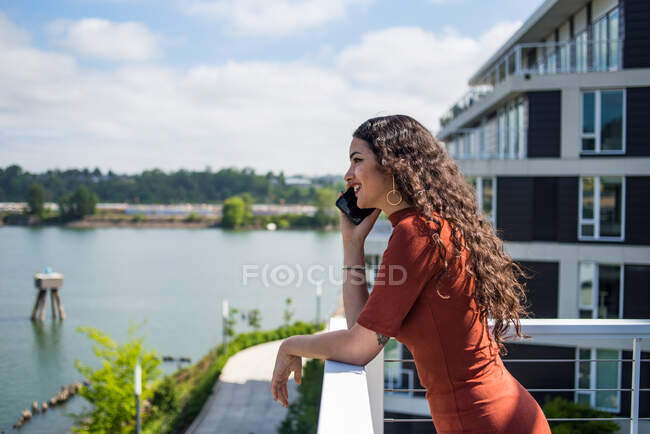 Красива молода жінка в сонцезахисних окулярах позує на фоні річки — стокове фото
