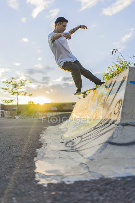 Patinador adolescente atlético haciendo una muela en skatepark, Montreal, Quebec, Canadá - foto de stock
