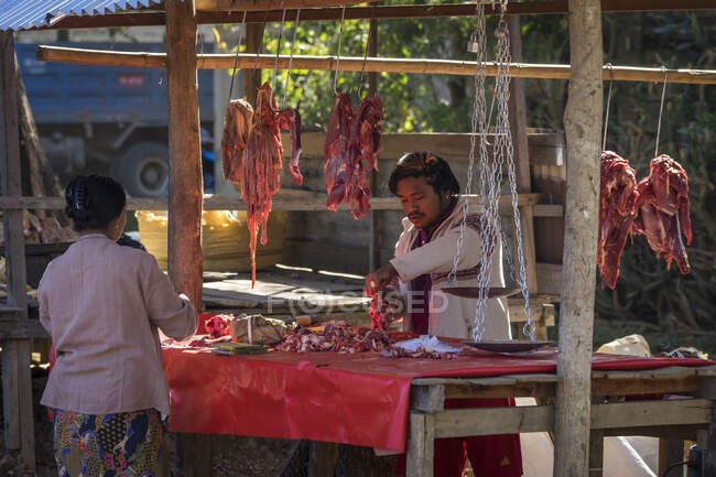 Человек, продающий мясо на уличном рынке в деревне, озере Инле, Ньяунгс — стоковое фото