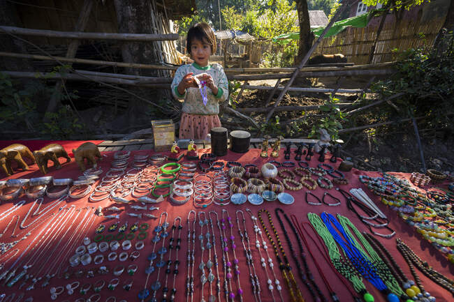 Fille vendant des souvenirs touristiques sur le marché de rue dans le village, La — Photo de stock