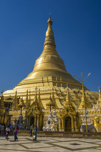 Tourists at gilded Shwedagon Pagoda against clear sky, Yangon, Y — Stock Photo