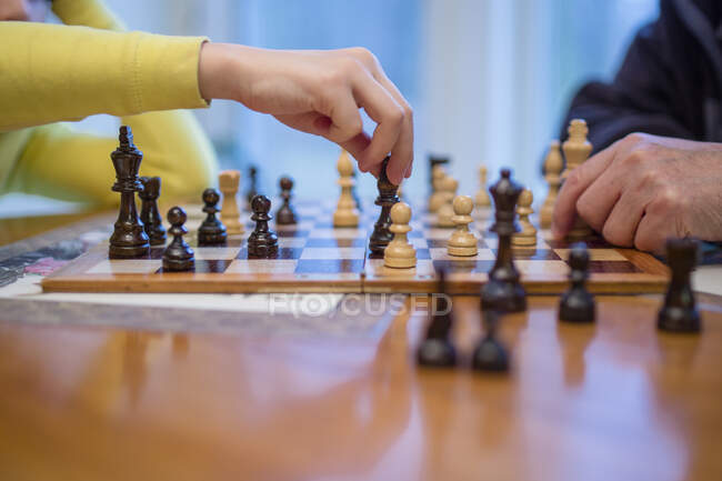 Primo piano di un uomo anziano e di un ragazzo che giocano a scacchi insieme — Foto stock