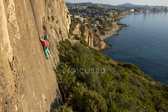 Mujer joven escalando en Toix Est, Calpe, Costa Blanca, Alicante provincia, España - foto de stock