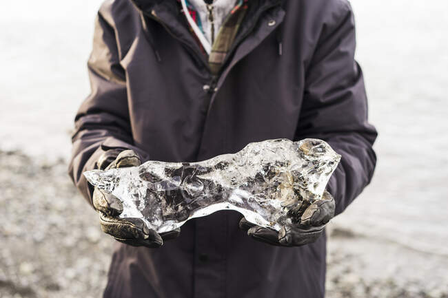 Pessoa Segurando pequeno iceberg em Jokulsarlon, Islândia, Europa — Fotografia de Stock