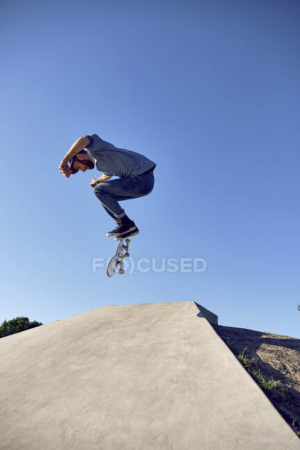 Skateboarder facendo Kickflip su rampa di cemento — Foto stock