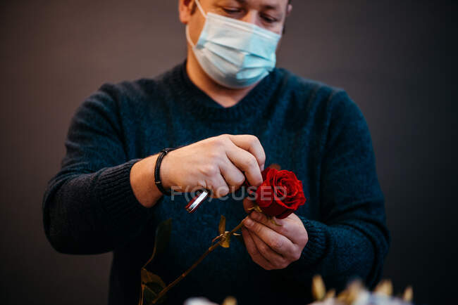 Glücklicher kaukasischer Florist, der rote Rosen zum Valentinstag verkauft — Stockfoto