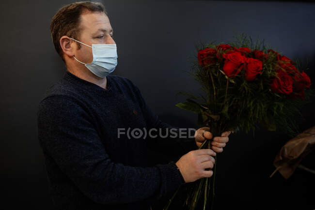 Florist making and selling bouquets of red roses for valentines day — Stock Photo