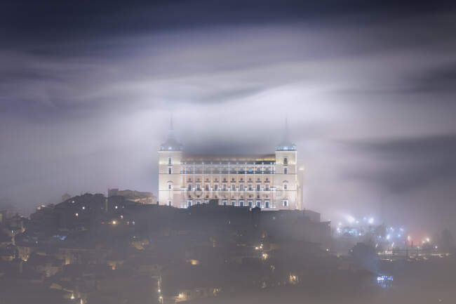 Vieux château enveloppé dans la brume la nuit, Alcazar de Tolède — Photo de stock