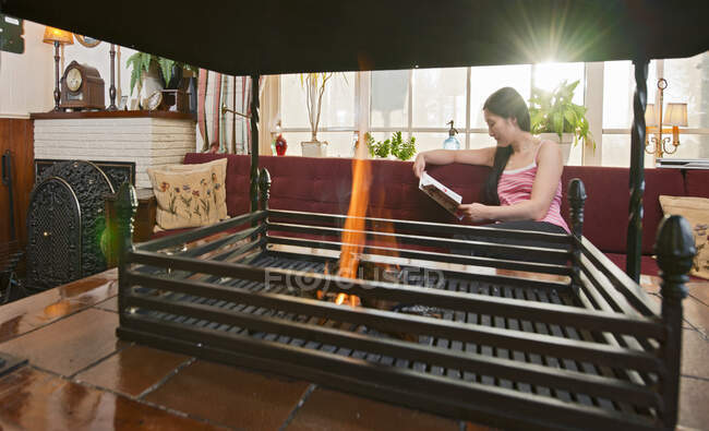 Woman relaxing at fireplace in hotel lounge in the Netherlands — Stock Photo