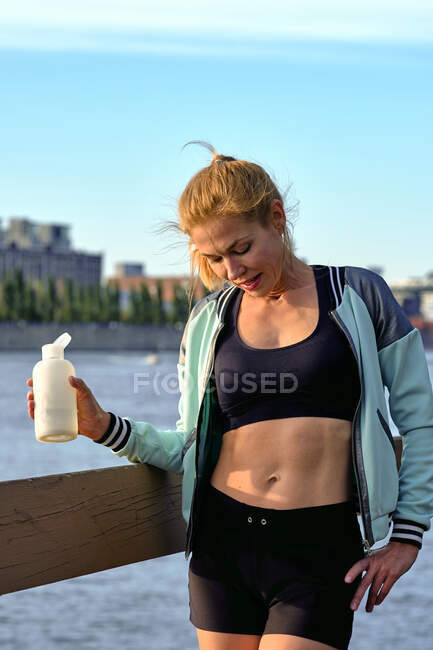 Athlète féminine en pause aquatique montrant son estomac musculaire, Montréal, Québec, Canada — Photo de stock