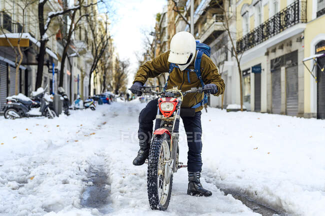 Ritratto di un uomo in moto per strada durante l'inverno — Foto stock