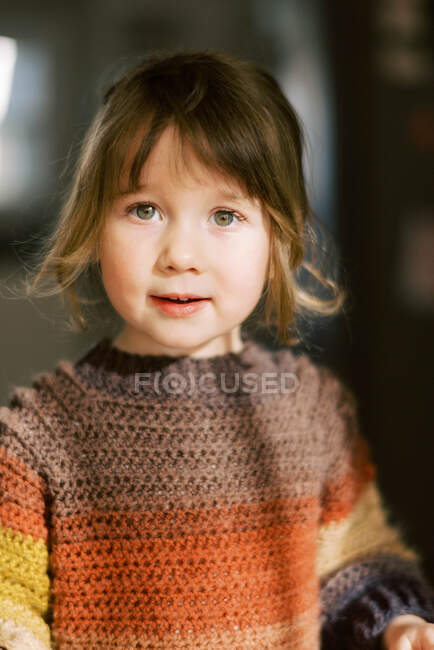 Gros plan de petite fille préscolaire avec des yeux brillants souriant dans la caméra — Photo de stock