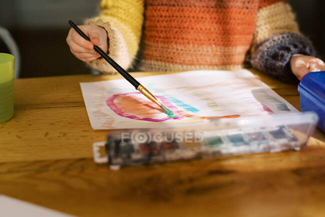 Piccola pittura prescolare ragazza con acquerelli al tavolo della cucina — Foto stock