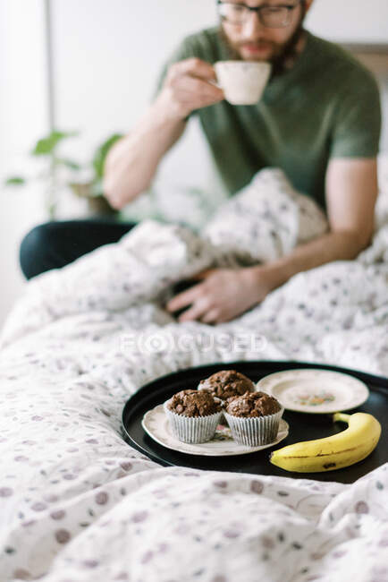 Homme hacing petit déjeuner sur le lit à la maison — Photo de stock